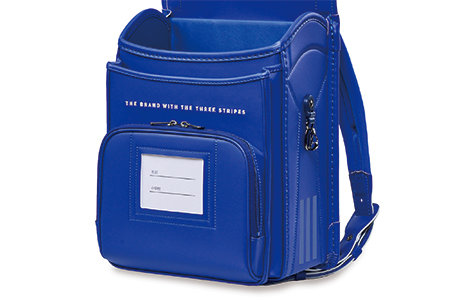 ラウンド型ポケットの上にスリーストライプスのブランドコンセプトししゅうをシルバーの糸で施し上品な仕上がり