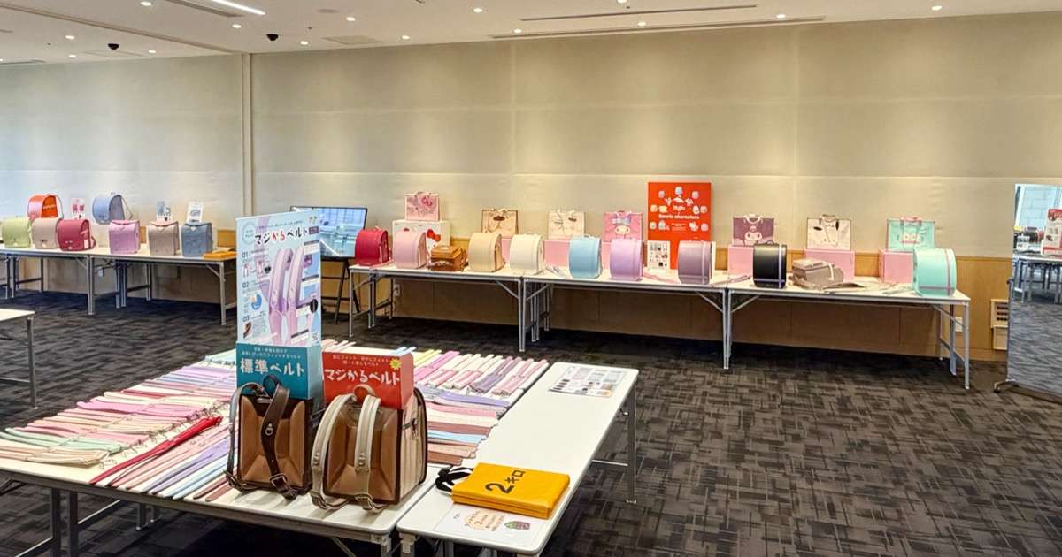 ランドセル展示会でスタッフが親子に背負い心地を説明している様子