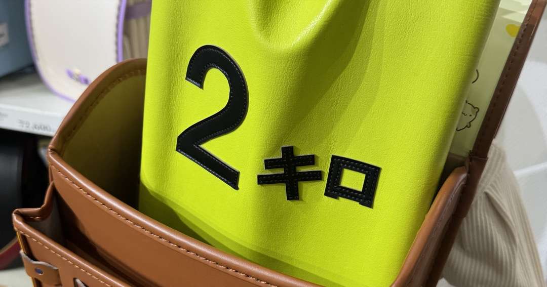 展示会で2kgの重りをランドセルに入れて子どもが試着している様子