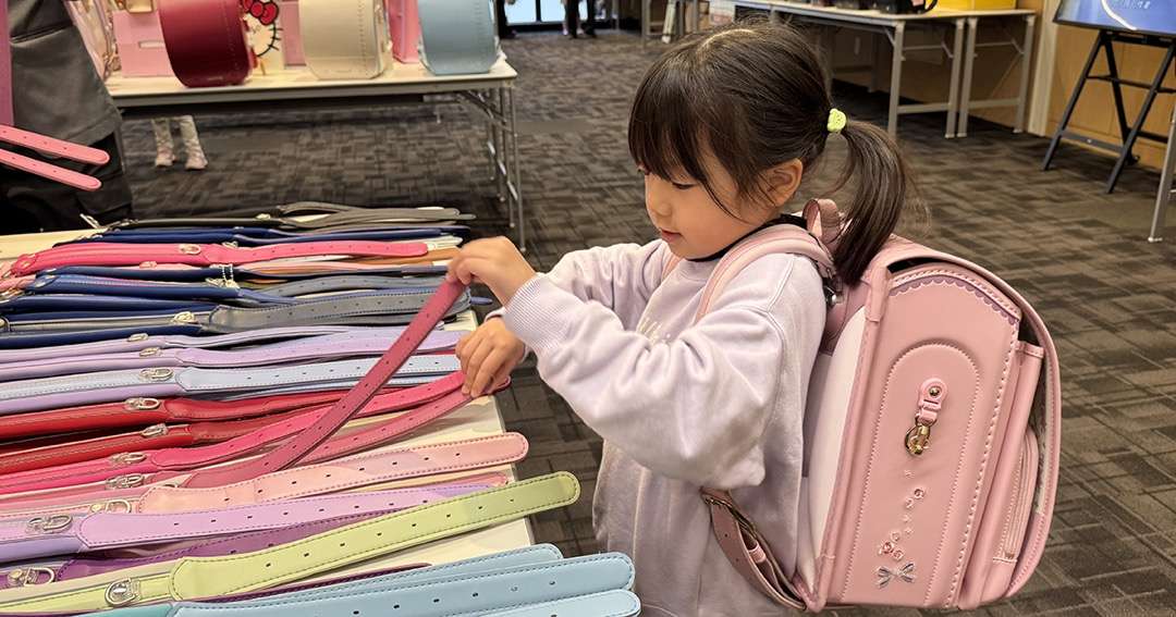 ララちゃんランドセル展示会で肩ベルトを手に取る女の子